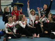 The Camas High School gymnasts celebrate with their coaches after being announced as the district champions Wednesday, at Northpointe in Vancouver.