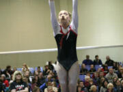 Camas freshman Emily Karkanen builds momentum on the bars before sticking her dismount during the 4A state gymnastics meet Friday, at the Tacoma Dome.