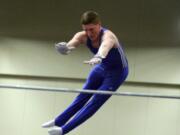 VEGA's Trace Jacquot, of Hockinson, flings himself over the high bar and catches it on the other side during the Level 10 USAG Washington state men's gymnastics meet Saturday, at the Clark County Event Center.