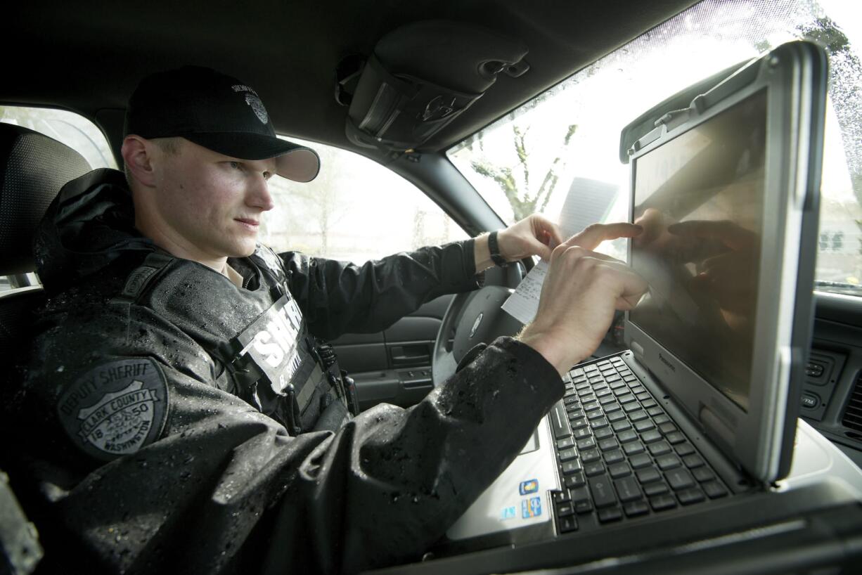 Deputy Bryce Smith checks his in-car computer during a patrol Tuesday.