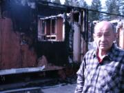 Ed Rodda stands before the charred remains of his double-wide mobile home in La Center.