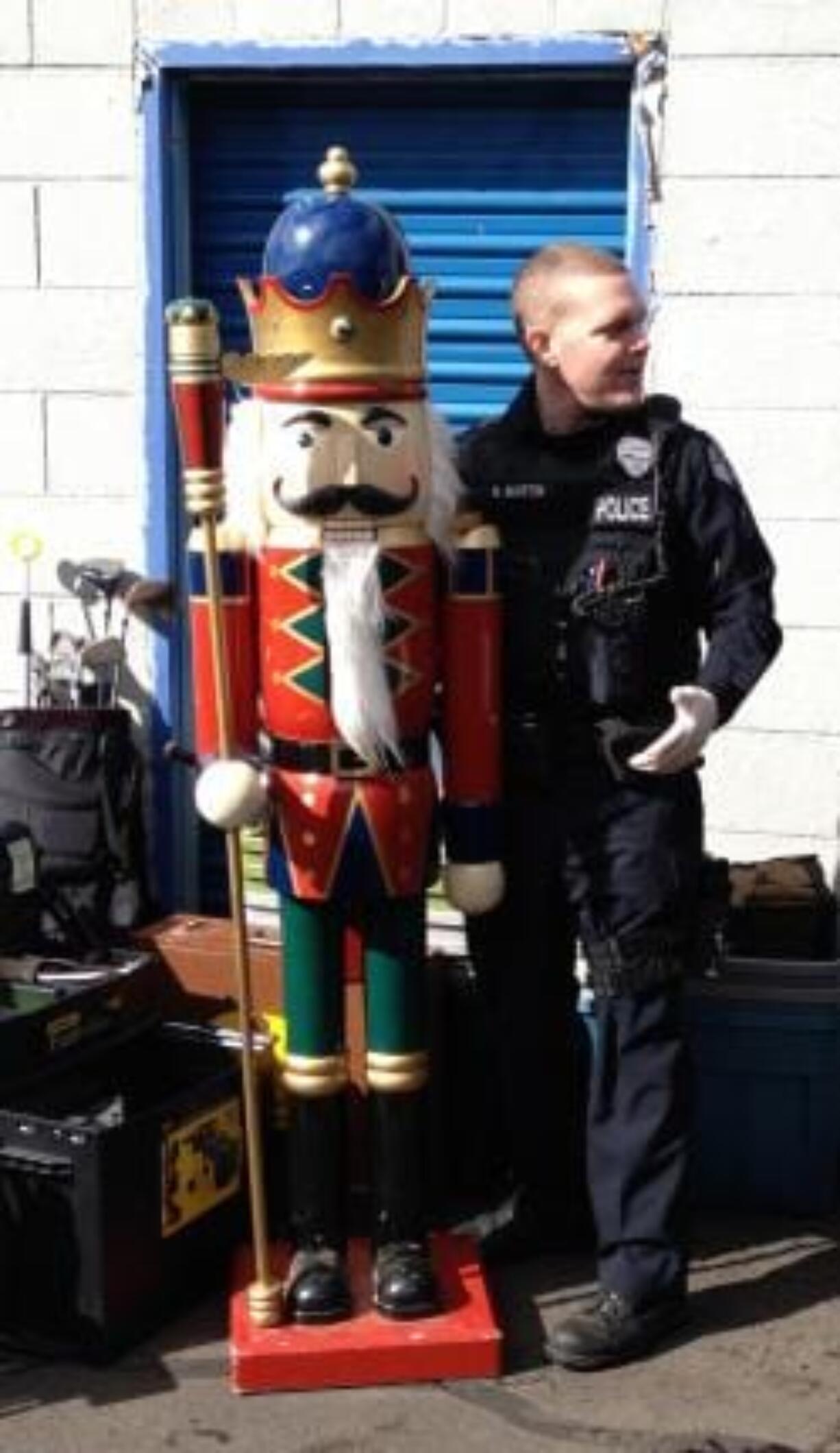 Vancouver police Cpl. Neil Martin, right, stands with a 6-foot nutcracker recovered from a storage unit.