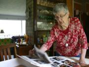 Wanda Turner flips through photos of friends, classmates and teachers at her potlucks over the years.