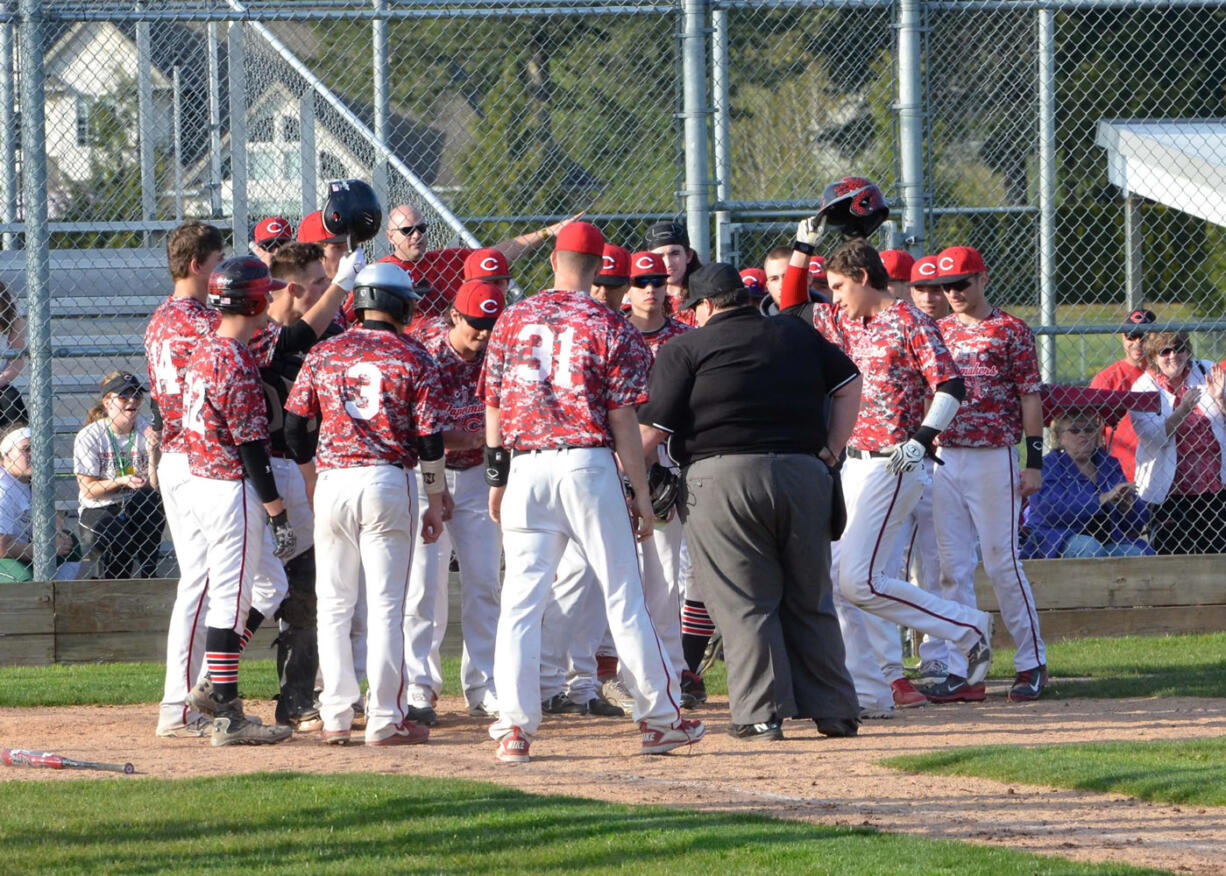 The Papermakers greet Reilly Hennessey at home plate after he hit a 3-run home run to put the finishing touches on a 14-2 victory against Skyview Monday, at Camas High School.