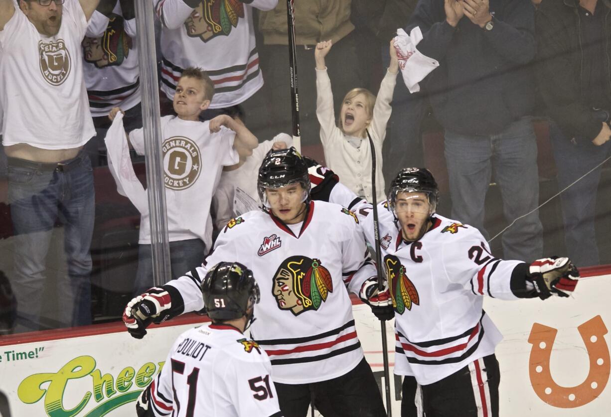 The Winterhawks' Anton Cederholm, center, celebrates with teammates Derrick Pouliot, left, and Taylor Leier after scoring against the Royals to take a 2-1 lead in the first period of game two in a second round match-up at the Moda Center on Saturday April 5, 2014.