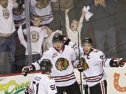 The Winterhawks' Anton Cederholm, center, celebrates with teammates Derrick Pouliot, left, and Taylor Leier after scoring against the Royals to take a 2-1 lead in the first period of game two in a second round match-up at the Moda Center on Saturday April 5, 2014.