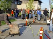 Alek Igumnov, left, is directed by Kelly Punteney, right, as he moves the stone into position.