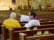 The Rev. Arcadio Munoz gives absolution to a parishioner at St. Mary's Church in Dumont, N.J.