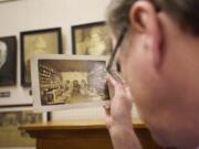 Tom Craig examines a vintage photograph that shows an earlier version of the Sparks store in downtown Vancouver.