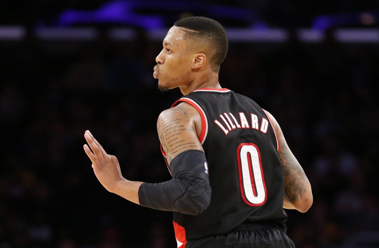 Portland Trail Blazers guard Damian Lillard reacts after making a three-pointer against the Los Angeles Lakers during the second half of an NBA basketball game in Los Angeles, Tuesday, April 1, 2014. The Trail Blazers won 124-112.