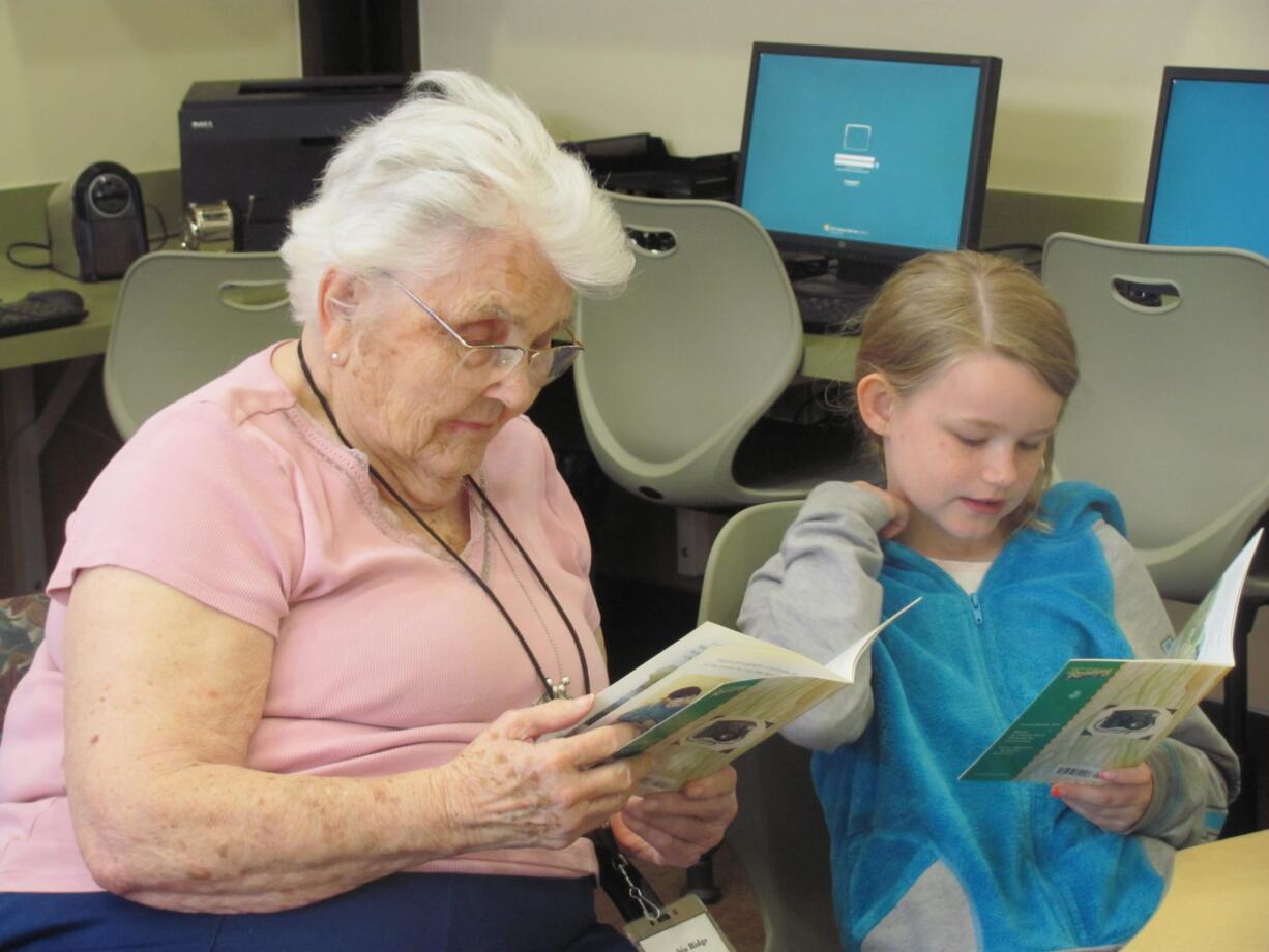 Volunteer Marilyn Adler listens to second-grader Trinity Archer read her a story. Adler is one of several volunteers from Columbia Ridge Senior Living who reads with students on a weekly basis.