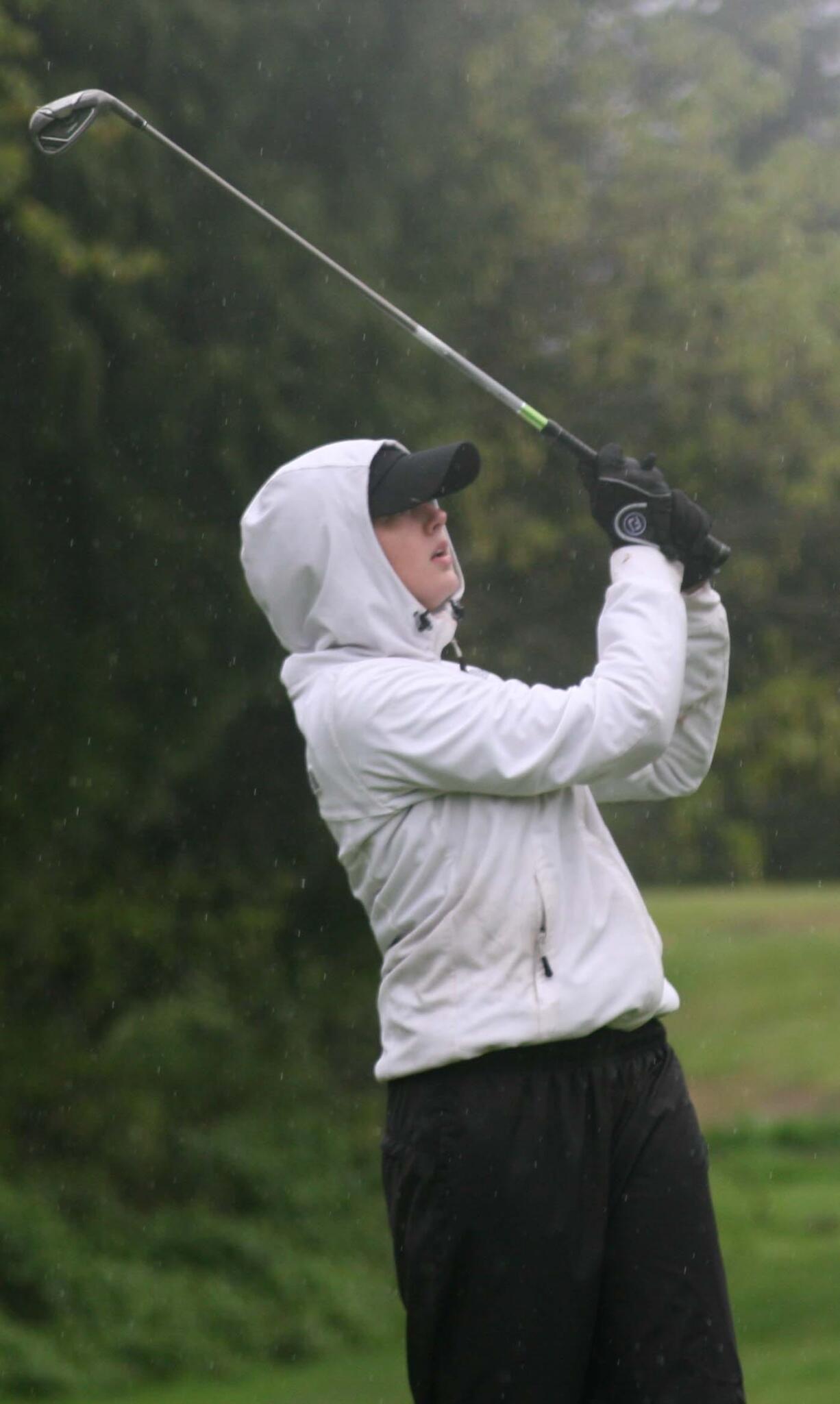 With blurry vision created by relentless rain drops, Molly Bilsborough lands her tee shot on the 17th green of the Lewis River golf course Thursday.