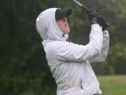 With blurry vision created by relentless rain drops, Molly Bilsborough lands her tee shot on the 17th green of the Lewis River golf course Thursday.