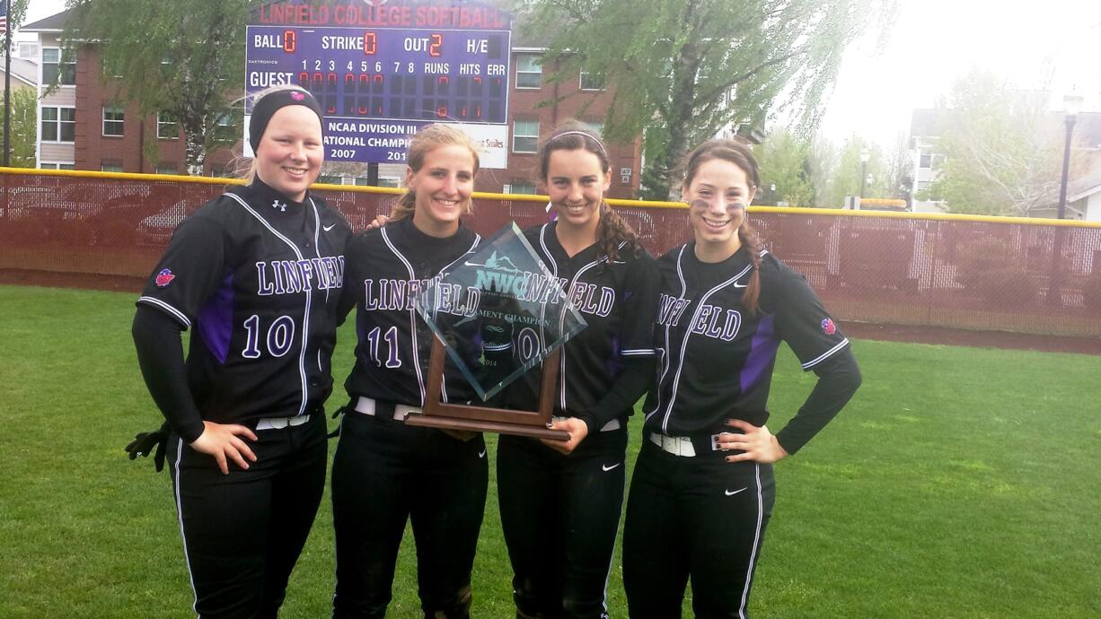 Linfield College softball players Erin Tauscher (Camas), Erin Carson (Camas), Grace Middelstadt (Prairie) and McKenna Spieth (Union), from left, with the 2014 Northwest Conference tournament championship trophy.