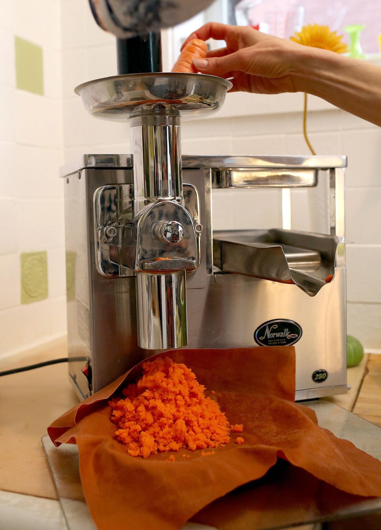 Amy Johnson makes a carrot and apple juice in February in her Central West End neighborhood home in St.