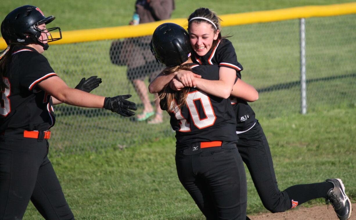 Kayla Lagerquist (left) and Abby Young (right) pounce on Madisen Baldwin after she drove in the tying and winning runs for Washougal in the bottom of the seventh inning.