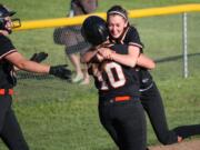 Kayla Lagerquist (left) and Abby Young (right) pounce on Madisen Baldwin after she drove in the tying and winning runs for Washougal in the bottom of the seventh inning.