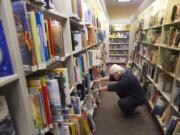 Librarian Sean McGill looks for a title at the Ridgefield library in March.