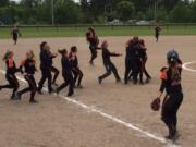 Battle Ground players celebrate their 6-3 victory over Emerald Ridge on Sunday at Kent, which put the Tigers in the Class 4A state softball tournament for the first time.