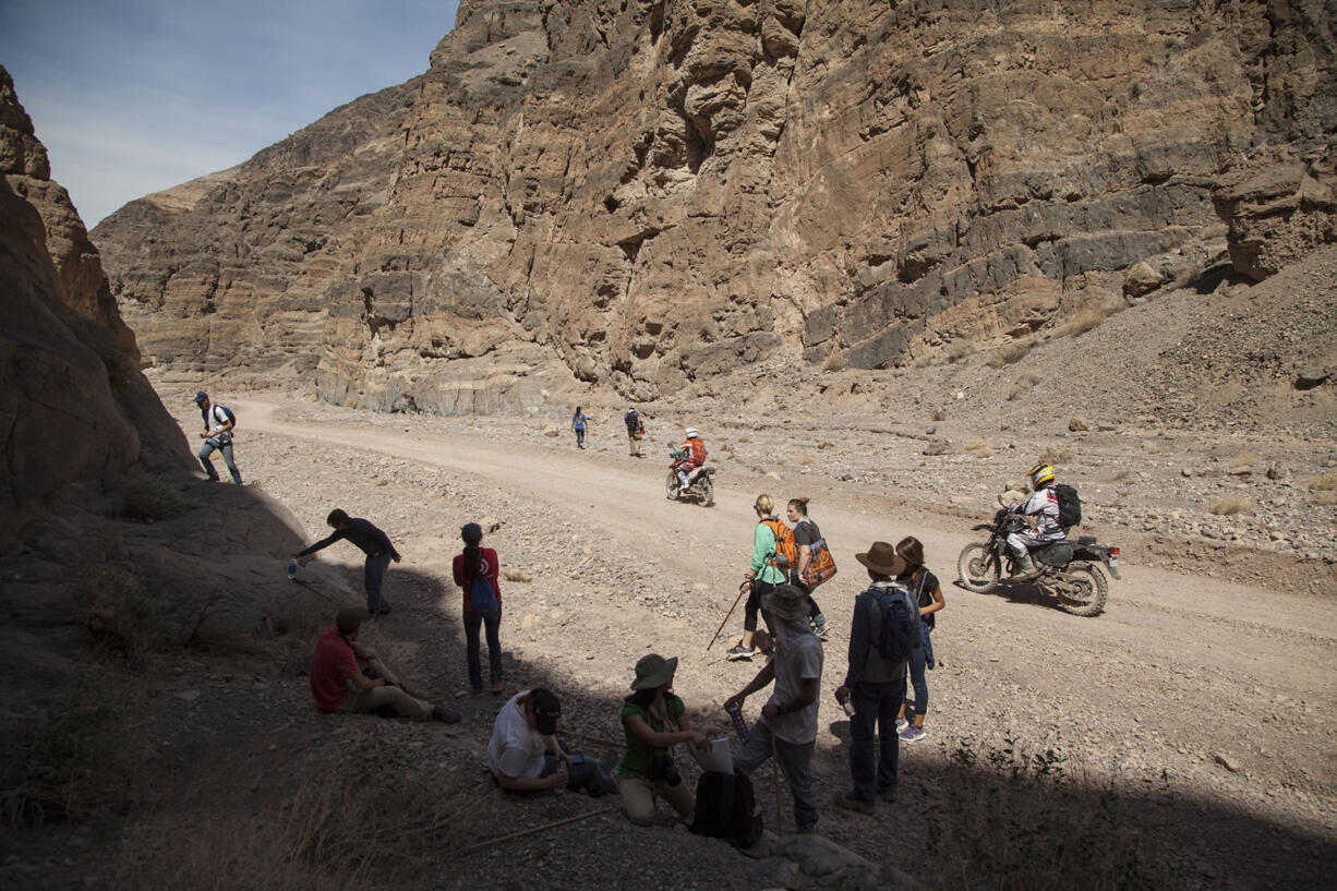 Almost completing their journey through Titus Canyon Narrows Mark Buche on a Honda CRF250L and Jun Villegas, riding a Suzuki DR-Z 400 encounter a geography class, field trip from West Hills College of Lemoore, Calif., exploring the desert, during their recent three day visit to Death Valley National Park.