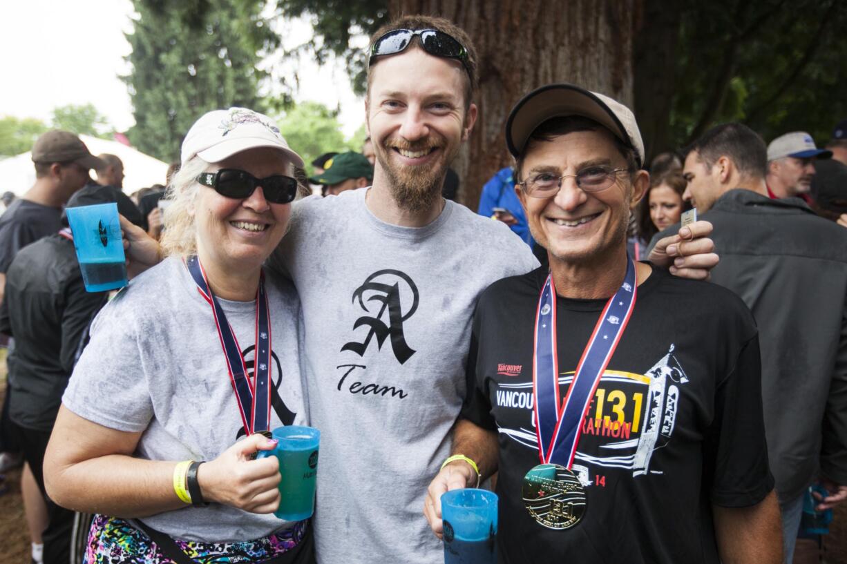 From left, Lori, Gene, and Eric Anderson -- aka the &quot;A Team&quot; -- brave the rain Sunday to celebrate Father's Day at the Summer Brewfest in downtown Vancouver's Esther Short Park.