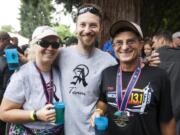 From left, Lori, Gene, and Eric Anderson -- aka the &quot;A Team&quot; -- brave the rain Sunday to celebrate Father's Day at the Summer Brewfest in downtown Vancouver's Esther Short Park.