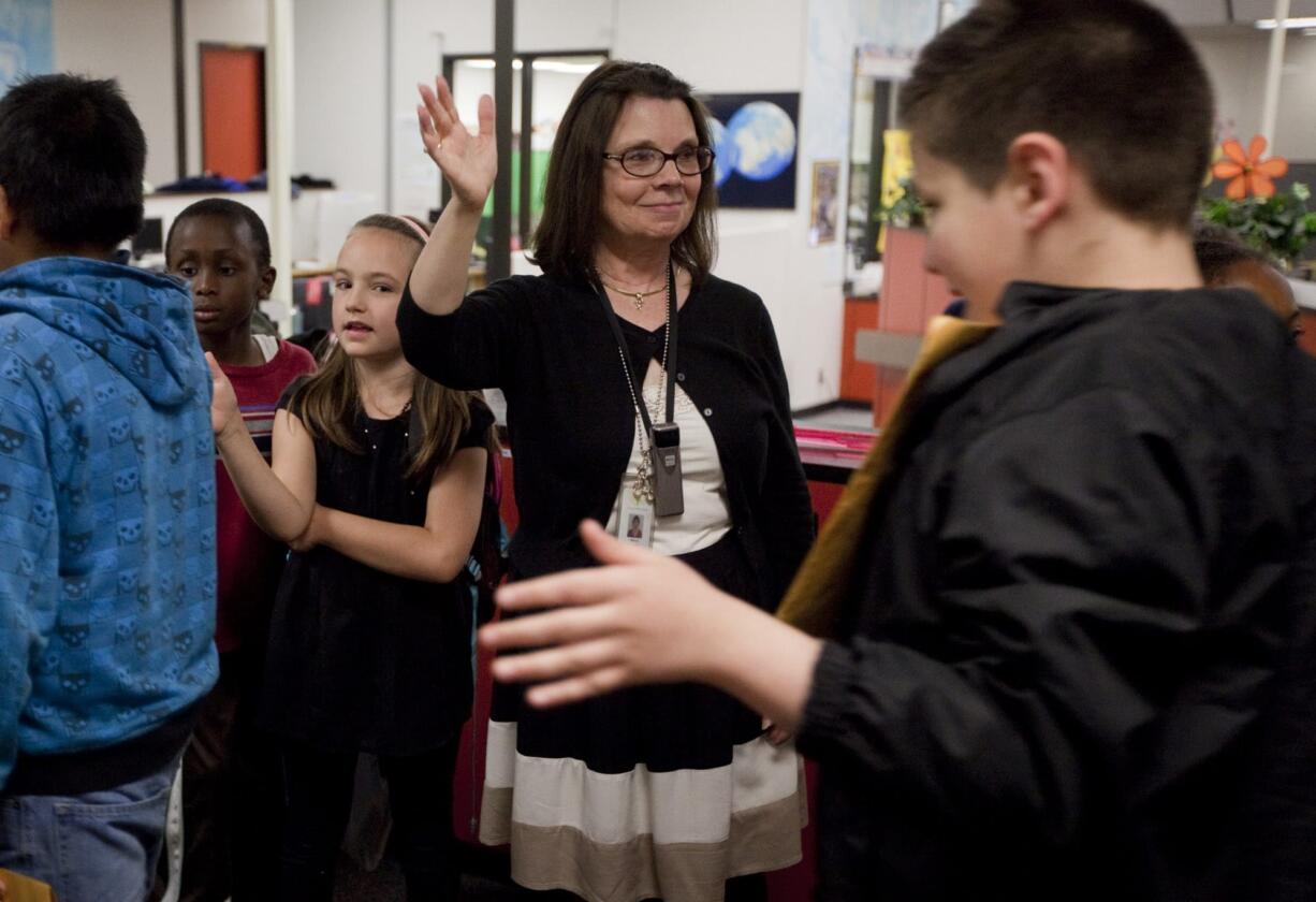 Fircrest Elementary teacher Nancy Lindsley high-fives fifth-graders, many her former students, on the last day of school Friday.