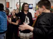 Fircrest Elementary teacher Nancy Lindsley high-fives fifth-graders, many her former students, on the last day of school Friday.