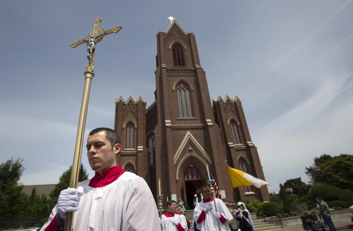 An altar server emerges, carrying a cross, from the Proto-Cathedral of St. James the Greater on Sunday.