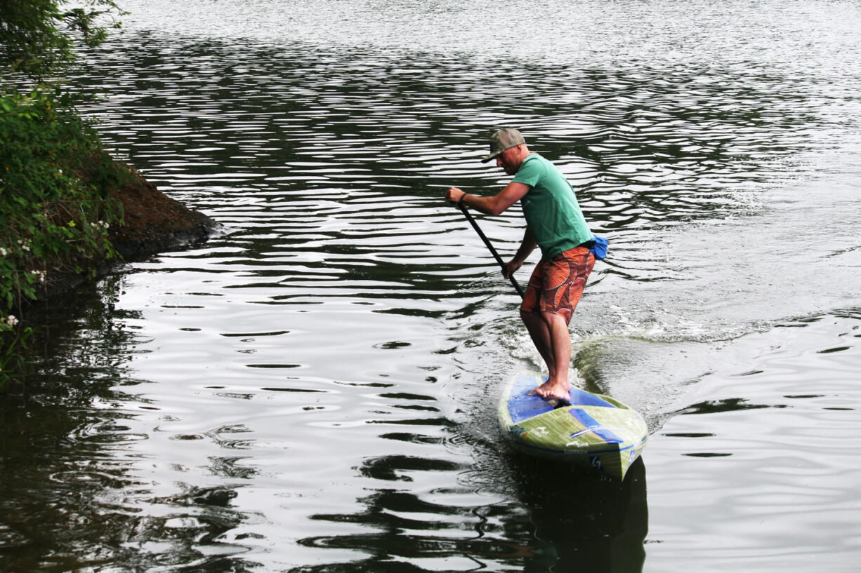 Erick Gelbke curls around the shore at Lacamas Lake. The Sweetwood Paddleboard guide, from Whitefish, Mont., loves tooling around the water with beginners and experienced riders.