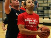 Firefighter Matt Baldwin gets by police officer Colton Price on a fast break during the Camas-Washougal Fire vs. Police charity basketball game.