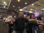 Congregation members exercise in their seats during a rally for pastor Rick Warrenu2019s u201cDaniel Planu201d at Saddleback Church in Lake Forest, Calif.