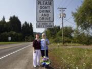 Connie Jones, left, and Marlys Thorp stand by a memorial sign dedicated to Roy Thorp, a 76-year-old Vancouver man who was killed three years ago by a speeding drunken driver on Northwest Hayes Road in Woodland.