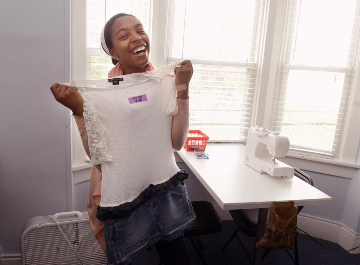 Micah Hudgins-Lopez, 13, shows off an outfit she made as part of the Maker's Place of the Oasis Project, which is run by the Bible Center Church in Homewood, Pa.