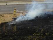 Firefighters extinguish a brush fire in the median of Interstate 5 south of Ridgefield.