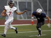 Camas High School's Liam Fitzgerald, left, moves past a tackle attempt from Chiawana High School's Josh Wilson during a Sept.