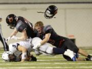 Camas defenders Adam Dawson, right, and Cole Zarcone take down Chiawana ball carrier Joey Zamora.