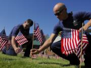 Ryan Beickel, left, and Andrew Wolf place flags honoring the victims of 9/11 in 2013 at the Clark County Fire District 3 station in Hockinson.