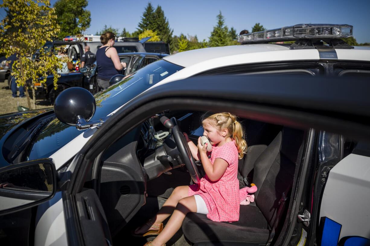 4-year-old Kinley Goertler from Camas gets hands-on with the inside of a City Of Vancouver Police patrol car during a recruitment event, that she inspired, for girls curious about careers in law enforcement Wednesday at the Vancouver Police East Precinct.