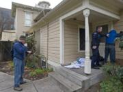 Vancouver Police Cpl. Drue Russell, left, runs a man's identification that he found camping next to the Slocum House in Esther Short Park while VPD Cpl. Duane Boynton secures the man after he disclosed to officers that he was carrying a knife, as part of an ongoing effort by authorities to make the park a safer place on Friday March 4, 2011.