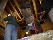 Nick, a 22 year-old appaloosa clydesdale cross, paints at the Danada Equestrian Center in Wheaton, Ill. Nick has been taught to paint using the clicker method, which rewards behavior with a clicking sound and food. Margaret Gitter clicks and gives Nick his treats, as Dan Neustadt assists Nick with the paint brush.