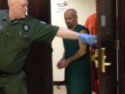 Ronald Ahlquist, 45, is escorted out of Clark County Superior Court after making a first court appearance on suspicion on second-degree manslaughter.