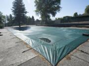 The Mount Vista neighborhood pool is seen covered and fallen in to disrepair in Ridgefield Thursday July 23, 2015.  The board  of the  Mount Vista Homeowners Association voted to decommission the pool, after the health department said it has pathogens, but some neighbors disagree.