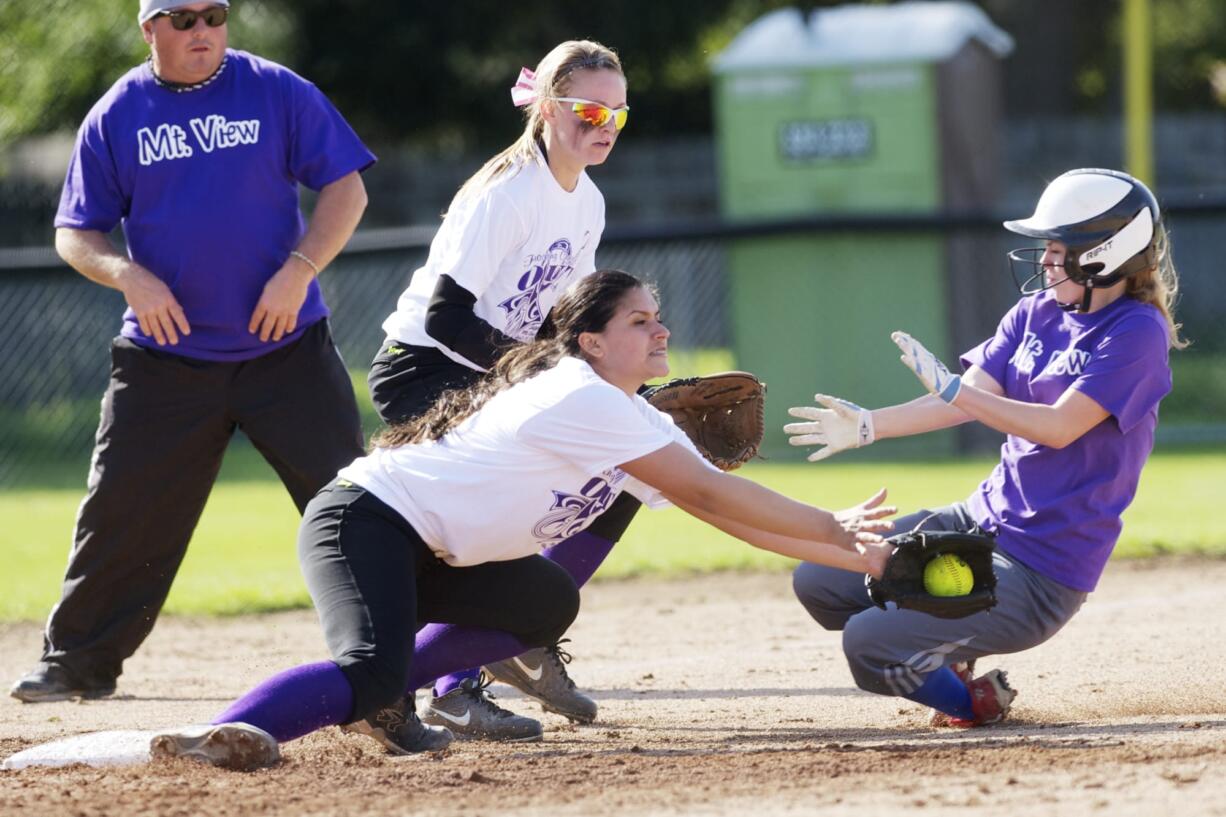 Mountain View's Lauren Warner slides into third under the tag of Prairie pitcher Irene McGuire as third baseman Jordan Shaw backs her up during a game, Monday, April 28, 2014.