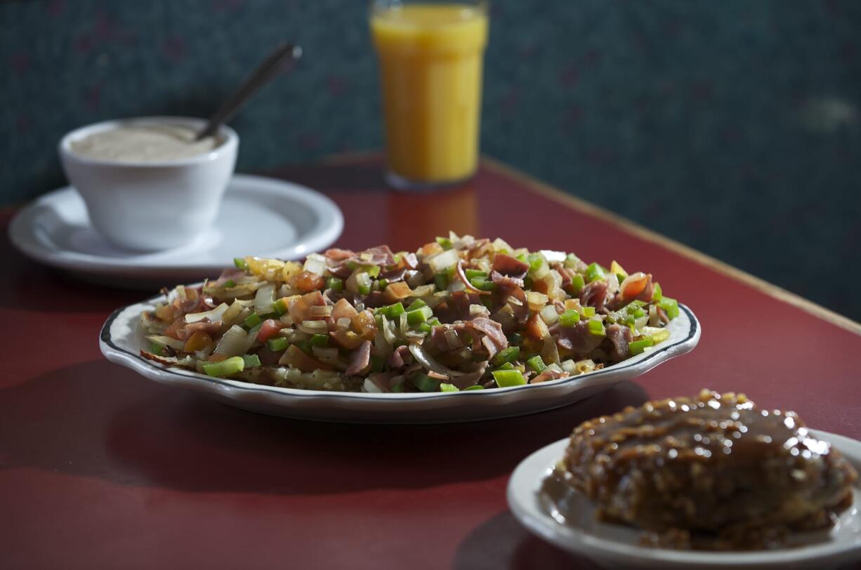 Farm-style potatoes with the gravy on the side and a homemade caramel and nut roll are among the menu items at Christine's Restaurant in Vancouver.