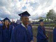 Turi Sado, 38, walks into the Sleep County Amphitheater with other Clark College graduates Thursday. Sado said he experienced a powerful moment in a Kenyan refugee camp seven years ago when he saw many people dying.