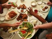 Meira Burnett, 11, lower right, reaches for salad dressing during a Sabbath dinner with her family Dec.