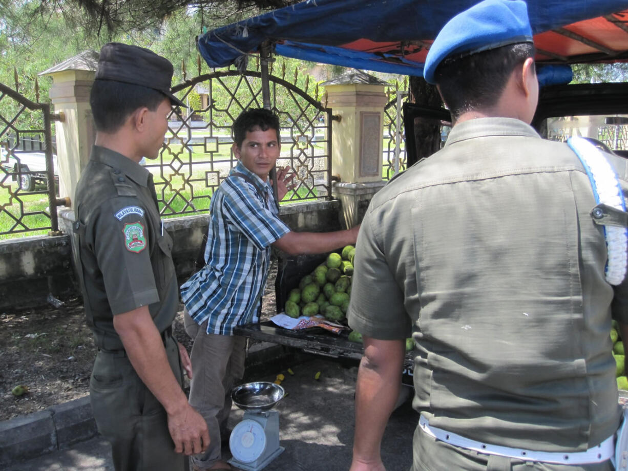 DON LEE/Los Angeles Times
Under the watchful eye of sharia police, street vendors outside the central mosque in Banda Aceh, Indonesia, shut down for the observance of midday prayers.