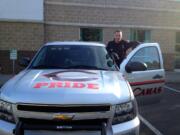 Camas Police Officer Tim Fellows, the Camas School District's school resource officer, with his newly restriped, Camas Papermakers-themed patrol car.