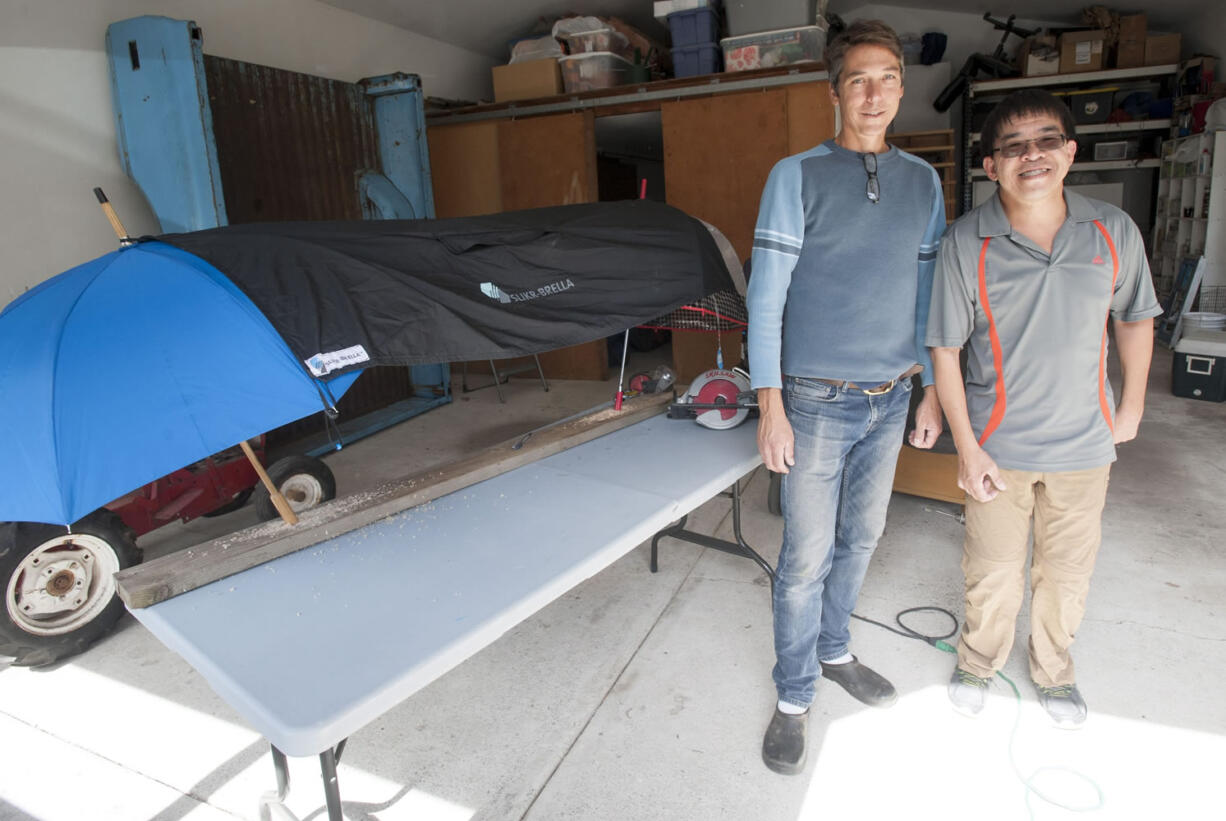Chris Gibbons and Kevin Chong stand in front of one of their Slikr-Brellas at Gibbons’ home in Vancouver. The men displayed their procut, a poncho that hooks over umbrellas to create a tent that can be used on the sidelines of sporting events, at the recent Wak, Roll ‘n Run event in Portland, a fundraiser for United Cerebral Palsy of Oregon. They plan to put any profits from the sale of their product into a new non-profit to help disabled people learn about finance and business basics.